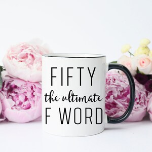 May include: White ceramic mug with a black rim and handle. The mug has black text that reads "FIFTY the ultimate F WORD".