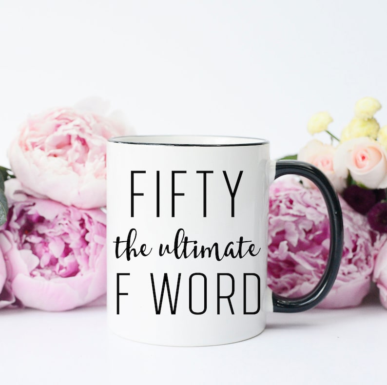 May include: White ceramic mug with a black rim and handle. The mug has black text that reads "FIFTY the ultimate F WORD".