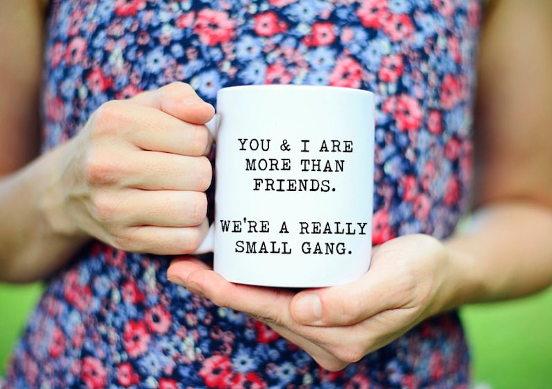 May include: White ceramic mug with black text that reads "You & I are more than friends. We're a really small gang."