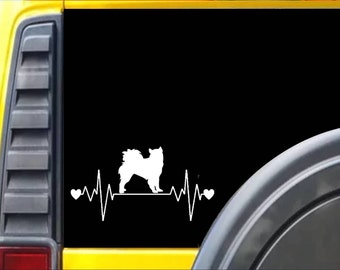 May include: White silhouette of a dog with a heartbeat line and two hearts on a black background. The image is on a yellow car.