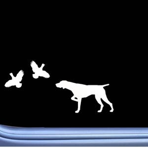 May include: White silhouette of a hunting dog with two birds in flight against a black background. The dog is in a poised stance, suggesting it is tracking the birds. The image is likely a decal or sticker.
