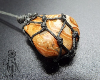 Op de afbeelding: Een bruine en oranje agaat steen is gewikkeld in een grijze macramé knoop. De steen heeft een draaiende patroon van bruin, oranje en wit.