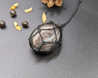 May include: A black obsidian stone pendant with a black cord wrapped around it in a geometric pattern.