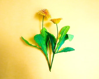 May include: Two yellow dandelions with green stems and leaves against a yellow background.