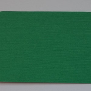 May include: A solid green card with rounded corners. The card is made of a textured paper stock.