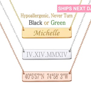 May include: Three gold, silver, and rose gold necklaces with personalized bar pendants. The pendants are engraved with the names "Michelle", "IV.XIV.MMXIV", and "40°5′57″N 74°58' 3"W".