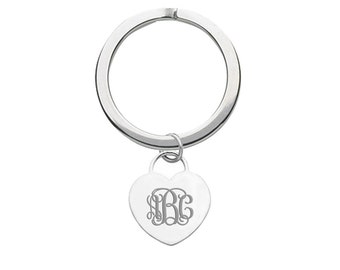 May include: A silver key chain with a heart-shaped charm. The charm has the letters "JBG" engraved on it.