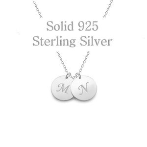 May include: A sterling silver necklace with two round pendants, each engraved with a single initial, "M" and "N". The text "Solid 925 Sterling Silver" is above the pendants. The chain and pendants are silver.