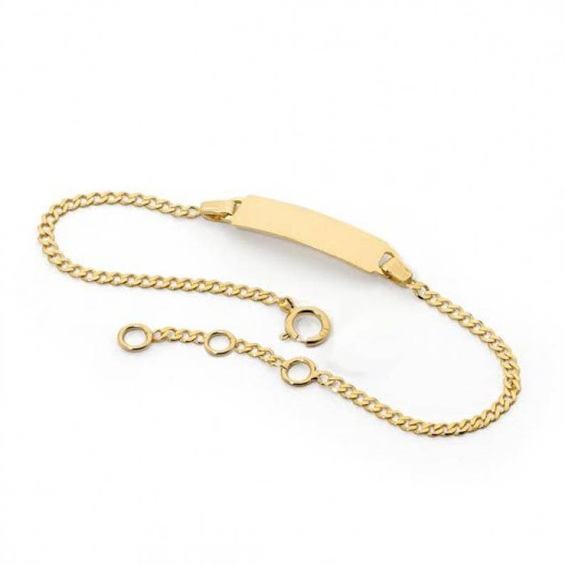 May include: A gold chain bracelet with a blank rectangular tag. The bracelet has a lobster clasp and an extension chain.