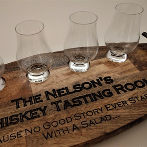 May include: Wooden serving tray with four small glasses and the text "THE NELSON'S WHISKEY TASTING ROOM BECAUSE NO GOOD STORY EVER STARTED WITH A SALAD..."