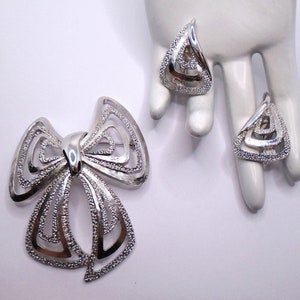 Vintage Textured and Polished Silver Tone Detailed Cut Out Bow Pin Brooch and Matching Tension Clip Earrings Set Designer Signed Monet