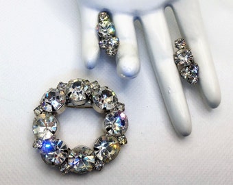 Può includere: Un set di gioielli vintage con una spilla circolare con strass trasparenti e un paio di orecchini abbinati con strass trasparenti.