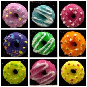 Puede incluir: Nueve mini donuts con diferentes glaseados y espolvoreados de colores. Las donuts están dispuestas en una cuadrícula de 3x3.