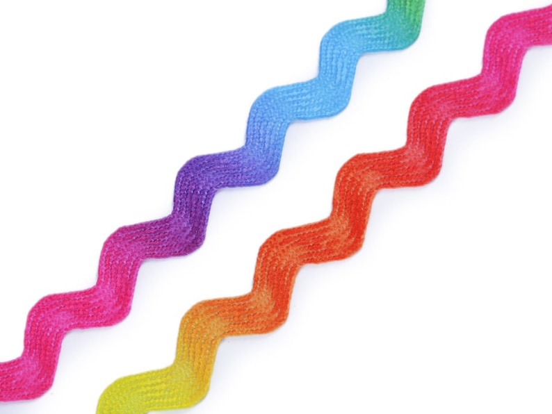 May include: Three zig-zag patterned ribbons in rainbow colors. The ribbons are arranged in a diagonal pattern, with the yellow and orange ribbon at the bottom, the red and purple ribbon in the middle, and the blue and green ribbon at the top.