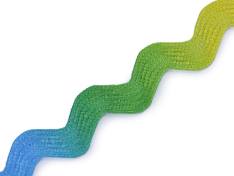 May include: A wavy, ombre ribbon with a blue to green gradient. The ribbon is made of a textured fabric.