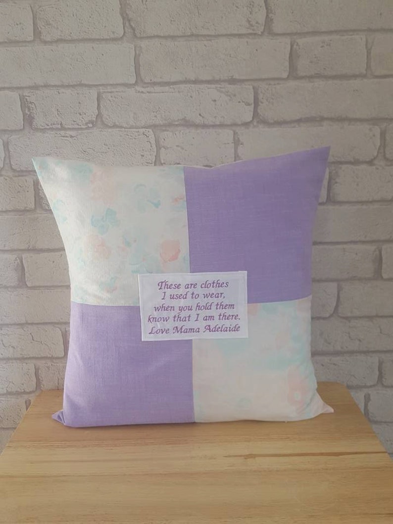 May include: A lavender and white patchwork pillow with a message embroidered on a small white square: "These are clothes I used to wear, when you hold them know that I am there. Love Mama Adelaide."