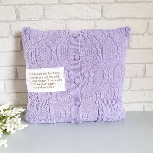 May include: A lavender knitted pillow with a white label that reads "Goodbyes are not forever. Goodbyes are not the end. They simply mean I'll miss you. Until we meet again. Love Mum xxxx".