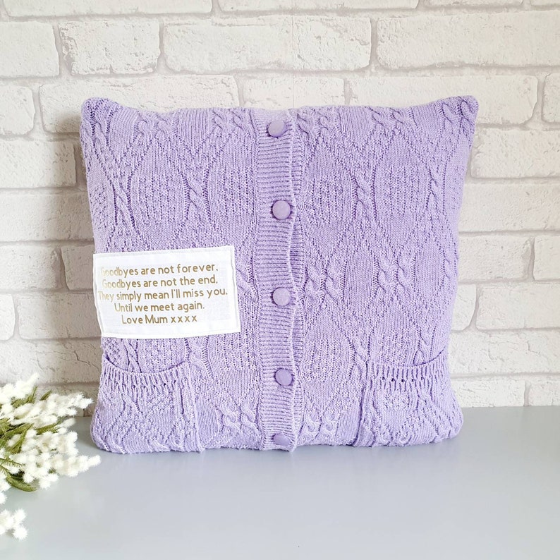 May include: A lavender knitted pillow with a white label that reads "Goodbyes are not forever. Goodbyes are not the end. They simply mean I'll miss you. Until we meet again. Love Mum xxxx".