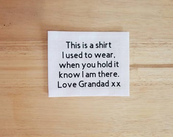 May include: White fabric square with black text that reads "This is a shirt I used to wear, when you hold it know I am there. Love Grandad xx"