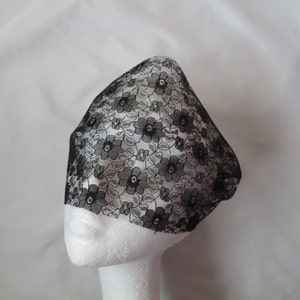 May include: Black lace veil with a floral pattern. The veil is on a white mannequin head.