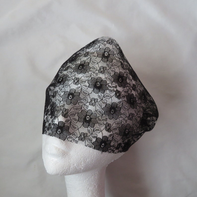 May include: Black lace veil with a floral pattern. The veil is on a white mannequin head.