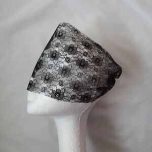 May include: Black lace hair covering with a floral pattern. The lace is delicate and sheer.