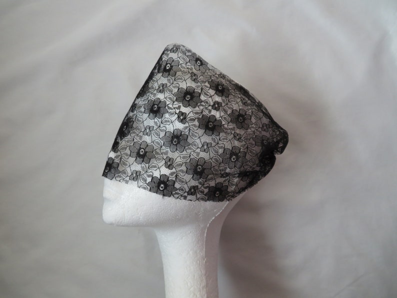 May include: Black lace hair covering with a floral pattern. The lace is delicate and sheer.