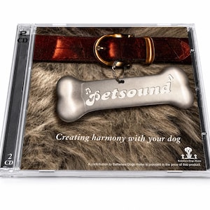 以下が含まれることがあります： 「Petsound」の文字が入った犬の骨型のタグと、金色のバックルが付いた茶色の革の首輪が特徴のCDケース。背景は毛皮のような質感です。「Creating harmony with your dog」と書かれています。