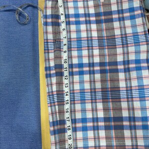 Peut inclure: Shorts &agrave; carreaux bleus, blancs et marron, avec un m&egrave;tre ruban indiquant une longueur de 53 cm. Le short pr&eacute;sente un motif &agrave; carreaux classique et une fermeture &agrave; bouton et fermeture &eacute;clair. Fabriqu&eacute; en tissu l&eacute;ger.