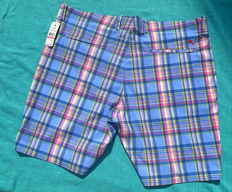 K&ouml;nnte beinhalten: Blaue karierte Shorts mit rosa, gelben und wei&szlig;en Akzenten. Die Shorts haben eine Ges&auml;&szlig;tasche und ein angebrachtes Etikett. Die Shorts sind aus einem leichten Stoff gefertigt, perfekt f&uuml;r warmes Wetter.