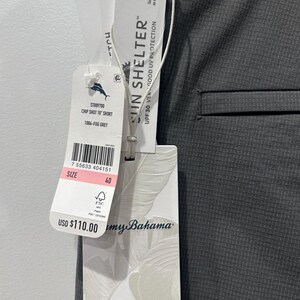 May include: Close-up of gray shorts with a tag. The tag reads "CHIP SHOT 10" SHORT" and "1086-FOG GREY". The tag also indicates "SUN SHELTER" with UPF 30 UV protection. The size is 40.