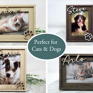 May include: Four rectangular wooden picture frames in light and dark wood finishes. Each frame features a cutout paw print in the corner and a custom name in script lettering at the top. The frames display photos of cats and dogs.