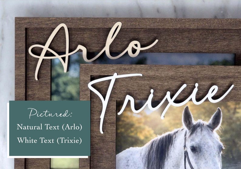 May include: A dark brown wooden picture frame featuring the name Arlo in natural wood lettering and the name Trixie in white lettering. A photograph of a white horse is displayed within the frame. A teal box contains the text Pictured: Natural Text (Arlo) White Text (Trixie).