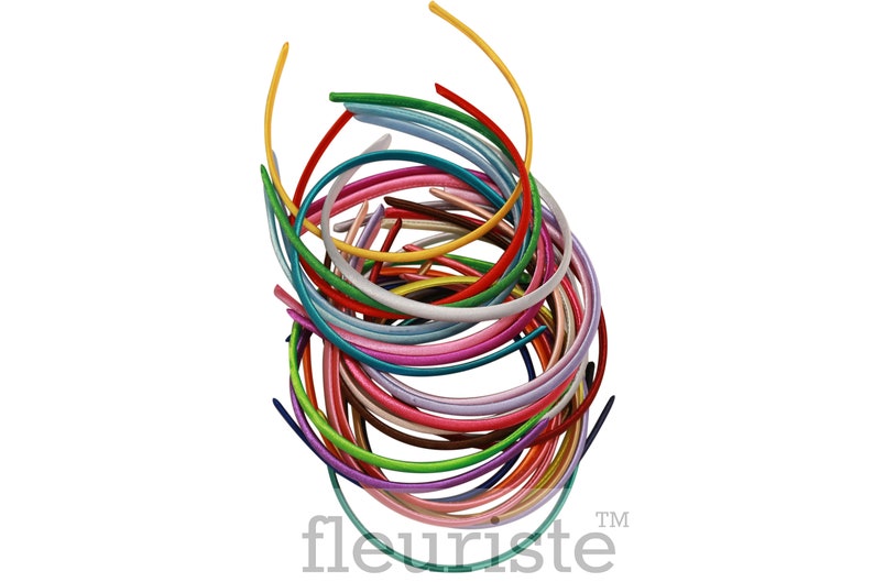 May include: A pile of colorful plastic headbands in various shades of pink, blue, green, yellow, red, and brown. The headbands are arranged in a circular pattern, creating a vibrant and playful display.