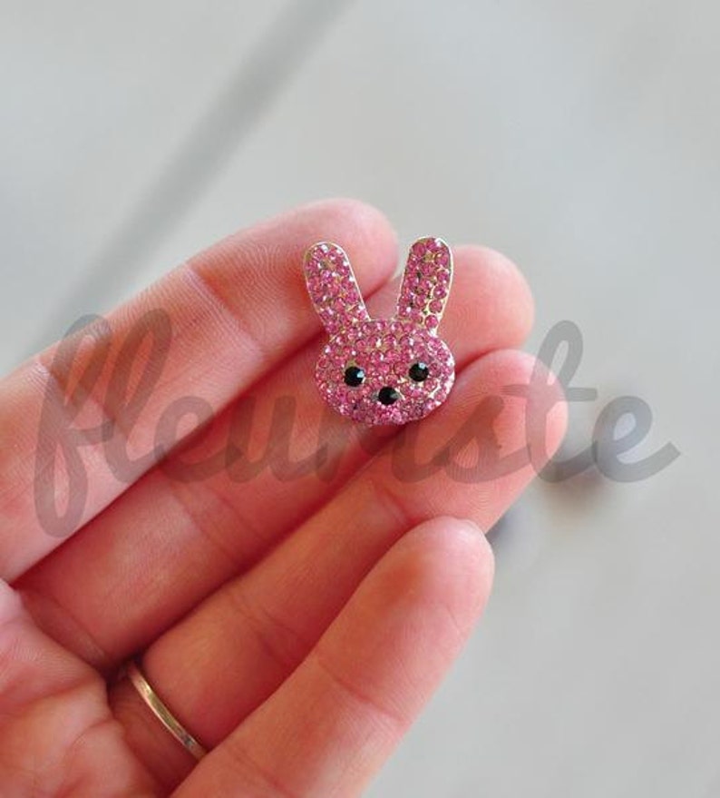 May include: Pink rhinestone bunny rabbit charm with black eyes.