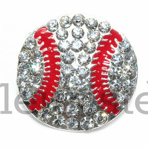 May include: A silver baseball charm with red stitching and clear rhinestones.