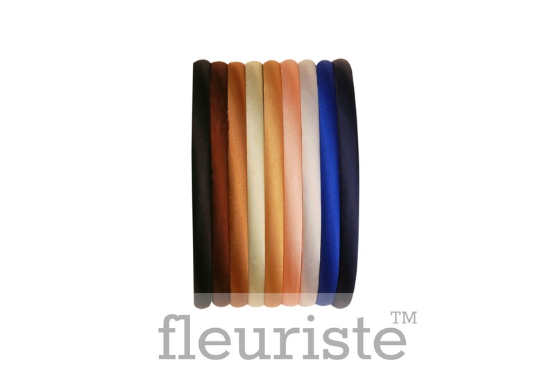 May include: A set of ten velvet headbands in various colors, including black, brown, beige, light brown, peach, pink, light blue, and dark blue.