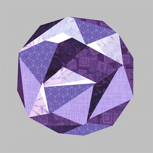 Könnte beinhalten: Eine geometrische Form in Lila mit einem 3D-Effekt, hergestellt aus verschiedenen gemusterten Stoffen.