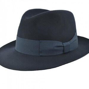 Può includere: Un cappello fedora blu scuro con un'ampia tesa e un nastro abbinato.