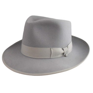 May include: A gray fedora hat with a gray ribbon and a button on the side.