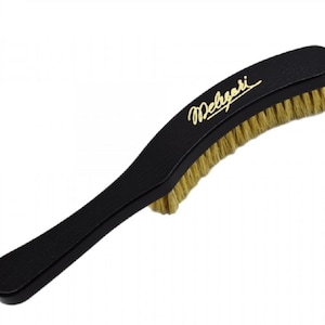 Op de afbeelding: Een zwarte schoenborstel met een lange steel en natuurlijke borstelharen. De borstel heeft de gouden tekst "Melgari" op de steel. De borstelharen zijn lichtbruin.