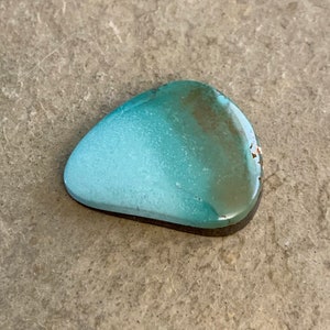 May include: A light blue and green turquoise cabochon with a smooth, polished surface. The stone has a natural, organic shape and is ideal for jewelry making.