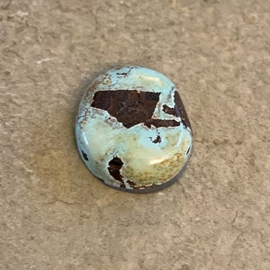 May include: A light blue and brown oval-shaped stone with a smooth surface.