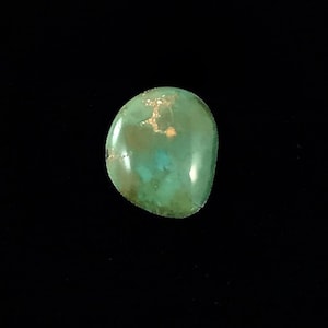 May include: A smooth, green and gold turquoise cabochon stone.
