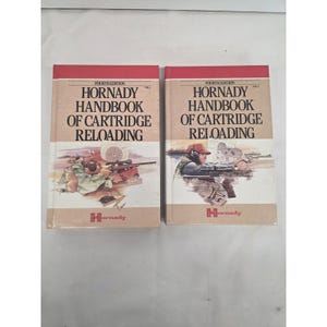 May include: Two hardcover books titled Hornady Handbook of Cartridge Reloading, Fourth Edition, Vol. 1 and Vol. 2. The covers feature illustrations of individuals using rifles and handguns at a shooting range, with the Hornady logo at the bottom.
