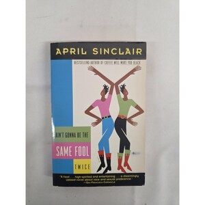 Pode incluir: Um livro de bolso intitulado Ain't Gonna Be the Same Fool Twice de April Sinclair. A capa apresenta uma ilustração gráfica de duas figuras a dançar sobre um fundo azul, branco e amarelo, com texto detalhando o autor e o título.