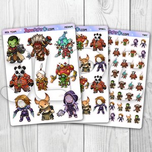 May include: A sheet of stickers featuring various cartoon characters in different sizes. The stickers are organized into three rows, with the top row labeled "Red Team", the middle row labeled "Medium", and the bottom row labeled "Small". The characters include a panda, a goblin, a robot, a fox, and a creature with wings. The stickers are printed on clear vinyl and are perfect for adding a touch of whimsy to your laptop, water bottle, or planner.