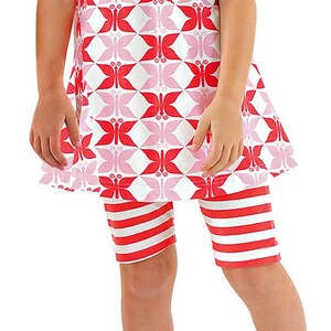 May include: A red and pink sleeveless dress with a butterfly pattern and red and white striped leggings. The dress has a gathered neckline and pink buttons on the straps.