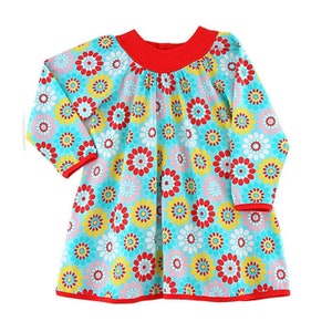 May include: A long-sleeved dress with a round neckline and a bright blue background. The dress is covered in a colourful floral pattern with red, yellow, and white flowers.