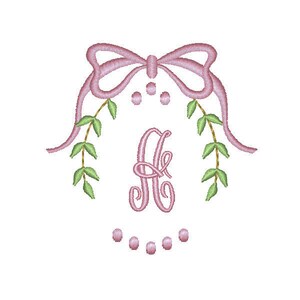 May include: A pink monogram with the letter "A" surrounded by a wreath of green leaves and a pink bow at the top.